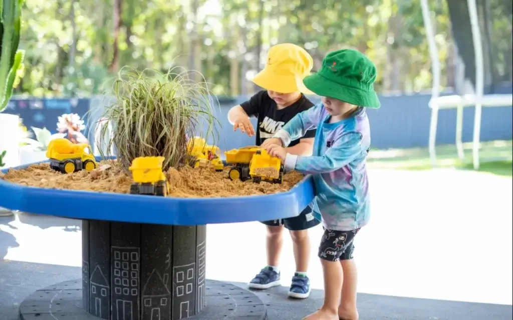 toddlers playing with trucks and sands